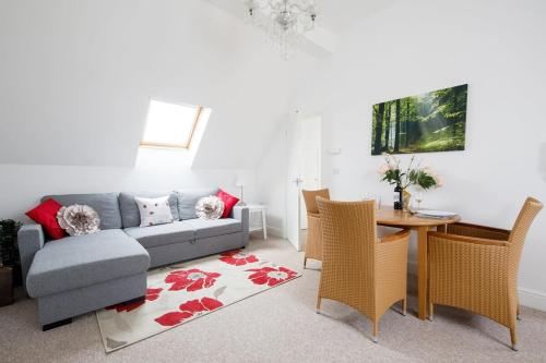 a living room with a couch and a table at Lovely Selsey apartment with sea views sleeps 4 in Selsey