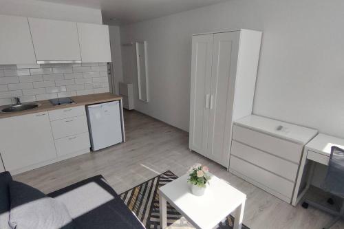 a kitchen with white cabinets and a table in a room at Light and useful stay in Kaunas