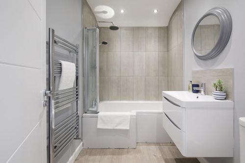 a white bathroom with a shower and a sink at Designer Seaside Escape King Beds Scenic View in East Wittering
