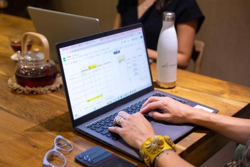 a woman typing on a laptop computer on a table at Lennox Buenos Aires in Buenos Aires