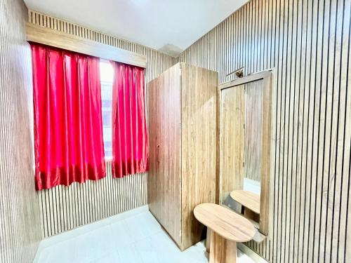 La salle de bains est pourvue d'un rideau rouge et de toilettes. dans l'établissement HOTEL SIDDHANT PALACE ! VARANASI fully-Air-Conditioned hotel at prime location, Lift-&-wifi-available, near-Kashi-Vishwanath-Temple, and-Ganga-ghat, à Varanasi
