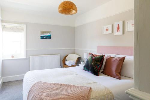 1 dormitorio con 1 cama blanca grande con almohadas en Camber - King Room in Gastro Pub, en West Wittering