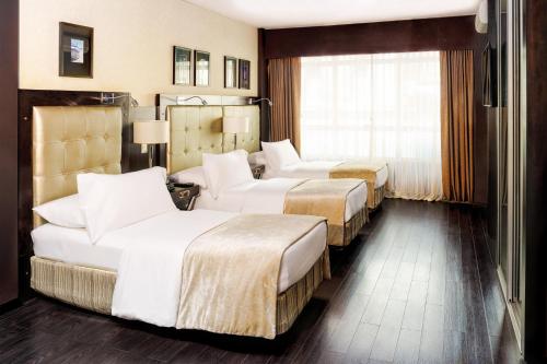 a hotel room with two beds and a couch at Lennox Buenos Aires in Buenos Aires