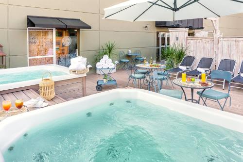 a hot tub on a deck with chairs and tables at Lennox Buenos Aires in Buenos Aires