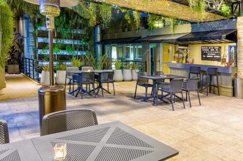 a restaurant with tables and chairs and plants at Lennox Buenos Aires in Buenos Aires