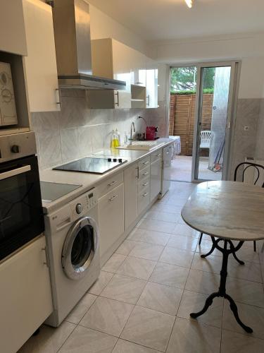 une cuisine avec une machine à laver et une table dans l'établissement ANTIBES appartement 2 chambres, à Antibes