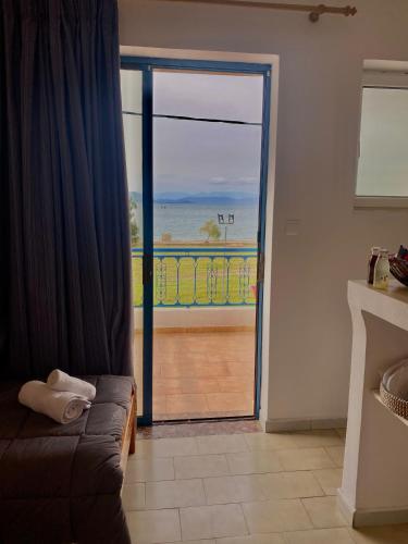 a living room with a door open to a balcony at Alexandra Studios in Néos Pírgos
