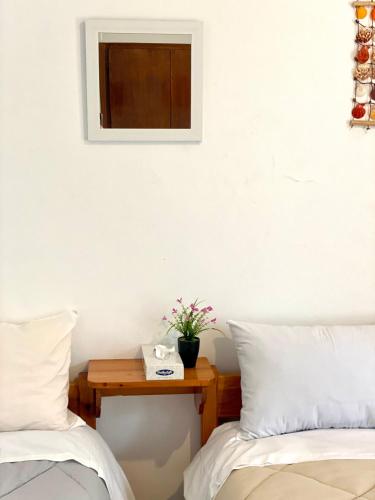 a bedroom with two beds and a table with a mirror at Alexandra Studios in Néos Pírgos