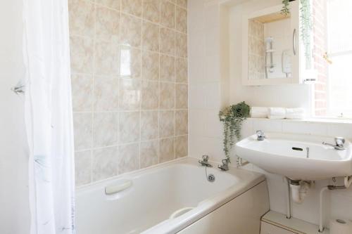 La salle de bains est pourvue d'un lavabo et d'une baignoire. dans l'établissement Sunny seafront chalet - sleeps 6, à Chichester