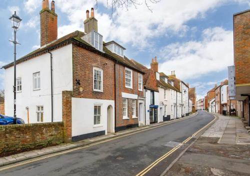 an empty street with a row of brick buildings at Charming four-bedroom central townhouse in Chichester