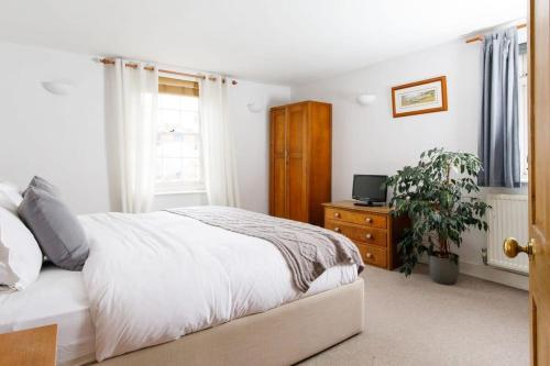 a bedroom with a bed and a tv on a dresser at Charming three-bedroom central townhouse in Chichester