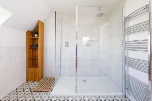 a shower with a glass door in a bathroom at Ultimate beach house with pool in West Wittering in West Wittering