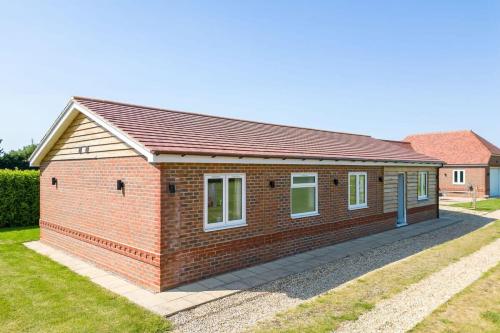 a house with a red brick at Countryside Bungalow for 4 Close to Beaches in Birdham