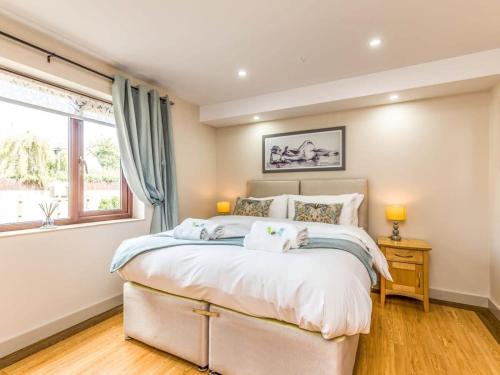 a bedroom with a large bed and a window at Modern Ground Floor Apartment with Parking in Fishbourne