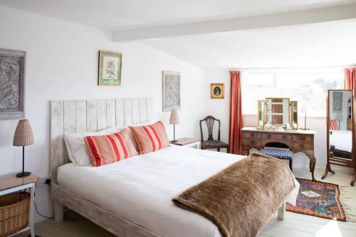 a bedroom with a large white bed with red pillows at Pretty Cottage Near City & Sea in Fishbourne