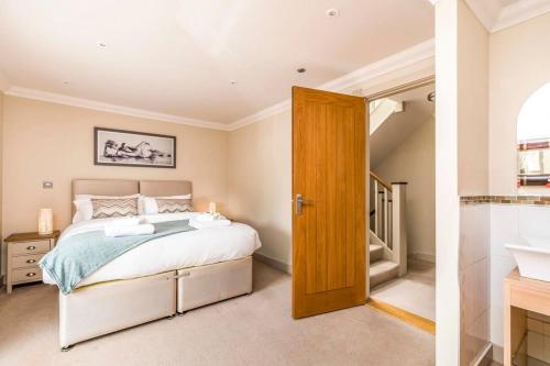 a bedroom with a king sized bed and a bathroom at Stylish 3 Bed with Double Carport in Fishbourne