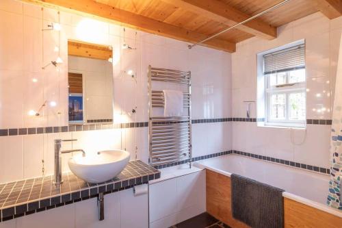 a bathroom with a sink and a bath tub at Stylist Split Level 2 Bed with Parking in Hambrook