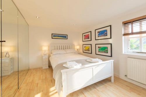 una camera bianca con letto e specchio di Stylist Split Level 2 Bed with Parking a Hambrook