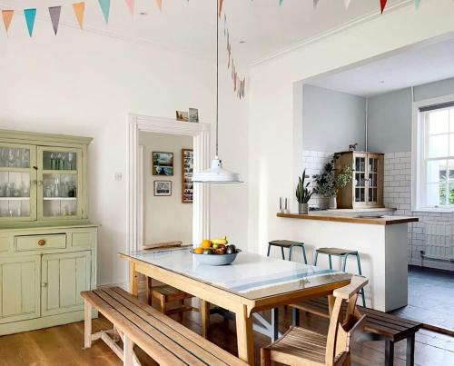 una cocina con una mesa con un bol de fruta. en Charming Town House With Garden & Sea View en Bognor Regis