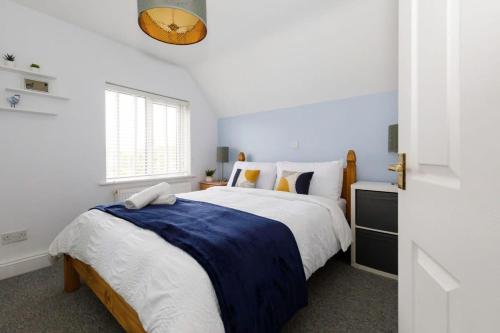 Un dormitorio blanco con una cama grande y una ventana en Two-bed beachside apartment West Wittering, en West Wittering