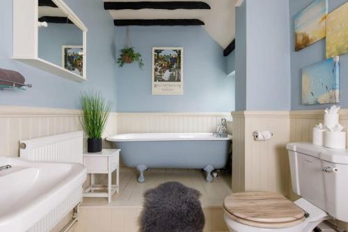 a bathroom with a tub and a toilet and a sink at Tranquil Luxe in Country Cottage in Bosham