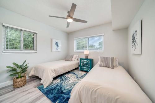 two beds in a room with a ceiling fan at Chic Home Near Airport Port Everglades & Casino in Fort Lauderdale