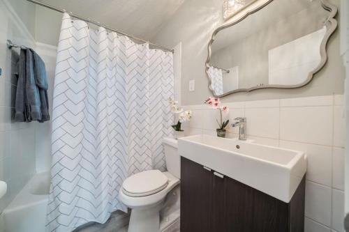 a bathroom with a toilet and a sink and a mirror at Chic Home Near Airport Port Everglades & Casino in Fort Lauderdale