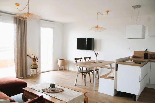 Il comprend un salon avec une cuisine et une table à manger. dans l'établissement La Madrague - front de mer, accès privé plage et place de parking, à Roscoff