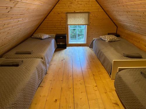 a attic room with two beds and a window at Tiku Holiday Homes in Kiidjärve