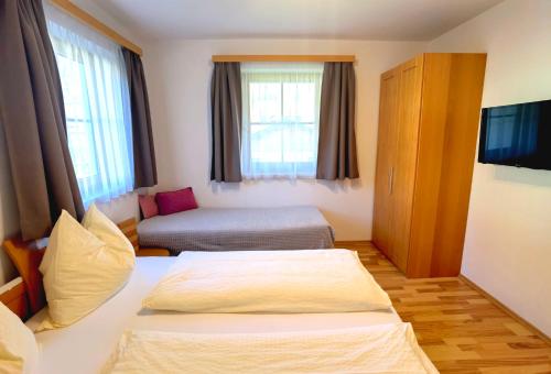 a hotel room with two beds and a television at Appartement Fritzenwallner in Wagrain