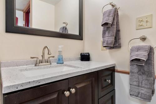 y baño con lavabo, espejo y toallas. en Cozy & Spacious Apartment Steps From Regis, en Denver