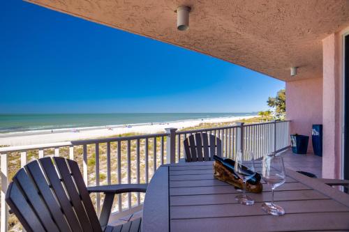 a table on a balcony with a view of the beach at Bella Luna, 2 bed and 2 bath beachfront condo in Bradenton Beach