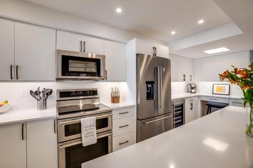 a kitchen with white cabinets and stainless steel appliances at Bella Luna, 2 bed and 2 bath beachfront condo in Bradenton Beach
