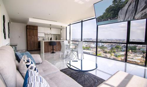 uma sala de estar com um sofá e janelas grandes em Suite 1202 Bellini, Puerto Santa Ana, Guayaquil em Guayaquil