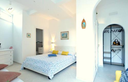 a white bedroom with a bed and an archway at LuSi Capri House in Capri