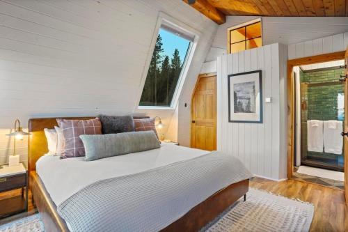 Un dormitorio con una cama grande y una ventana en Cedar Mountain Lodge With Hot Tub Views And Wildlife, en Evergreen