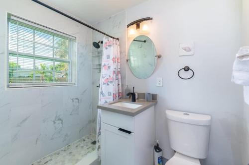 a bathroom with a toilet and a sink and a shower at Beachtown Getaway with Tiki Hut in Pompano Beach