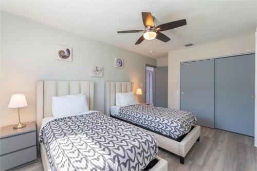 a bedroom with two beds and a ceiling fan at Beachtown Getaway with Tiki Hut in Pompano Beach