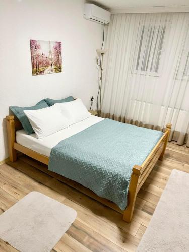 1 dormitorio con 1 cama con edredón azul en Nesi apartmenti, en Pristina