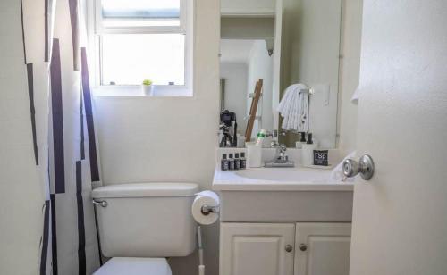 a bathroom with a toilet and a sink and a window at Bright, comfortable Studio with fast WiFi in Los Angeles