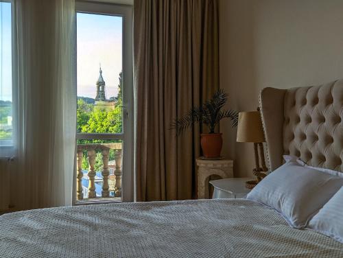 a bedroom with a bed and a window with a view at Veranda Boutique Hotel Kutaisi in Kutaisi