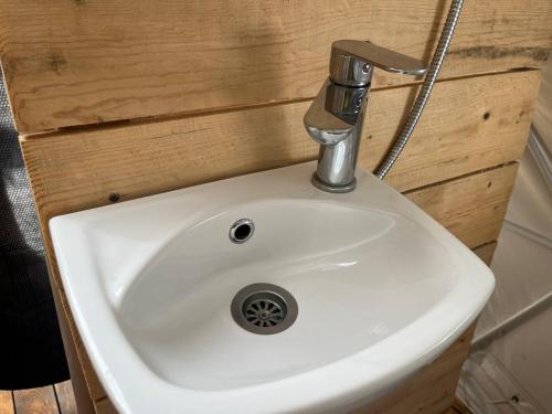 um lavatório branco numa casa de banho com uma torneira de metal em Glamping ROSE (Luštica Bay) em Radovići