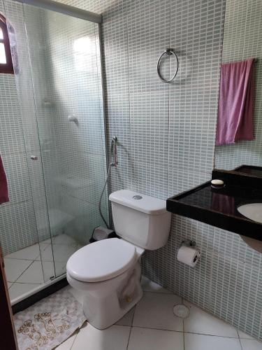 uma casa de banho com um WC e uma cabina de duche em vidro. em Casa em Gravatá em Gravatá