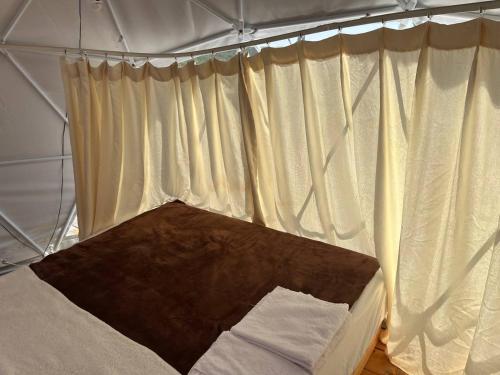 拉多維奇的住宿－Glamping ROSE (Luštica Bay)，帐篷内的一张床位,配有白色窗帘
