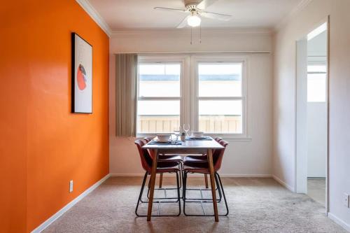 a dining room with orange walls and a table and chairs at Fast Wifi Luxury 1br Prime Location Huge Bed in Los Angeles