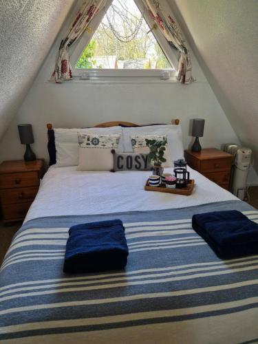 a bedroom with a large bed with two blue pillows at WOW! Amazing SEA VIEWS at Coastal chalet in Kingsdown Park with pool No 40 in Kingsdown
