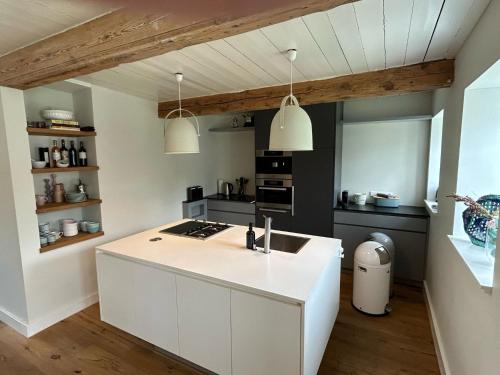 a kitchen with a white island in a room at Kapitänshaus von 1712 - neu saniert in Nieblum