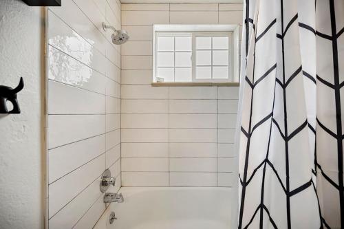 a bathroom with a shower with a black and white shower curtain at 1 1 Bright Corner Unit Walkability & Close to Hospitals in Englewood