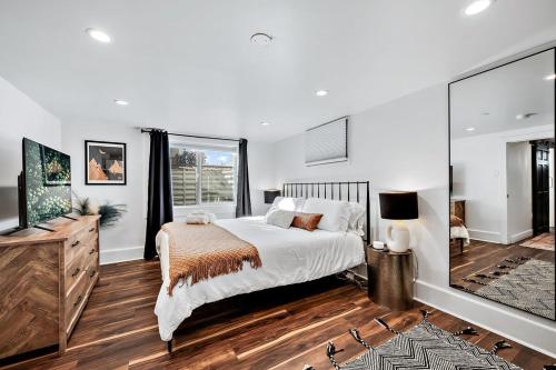 1 dormitorio con 1 cama grande y TV en Stylish 2 Bedroom Apt Steps From Regis Tennyson St en Denver