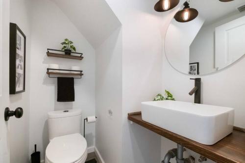 uma casa de banho com um lavatório branco e um espelho. em Farmhouse Design + Fire Pit in Heart of Pittsburgh em Pittsburgh